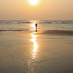 Glowing sunset on golden sands at Varca beach Goa