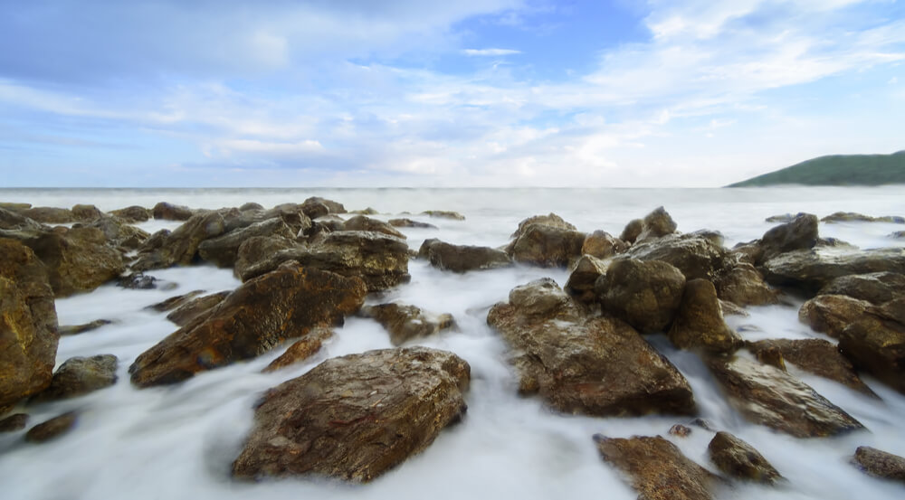 The beautiful silky smooth water waves and rocks at Yarada Beach, Visakhapatnam, India